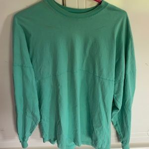 Aqua colored shirt with outer banks on the back